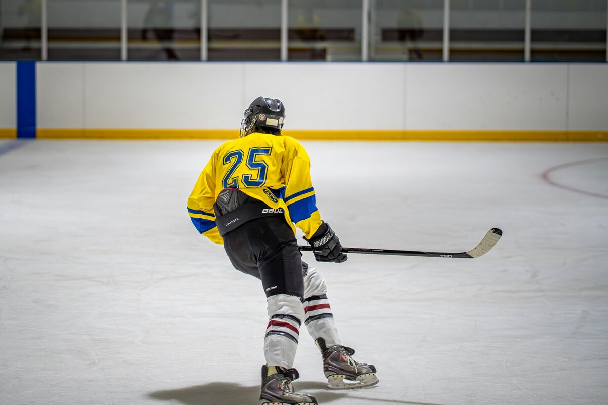 Lapsi luistelemassa jääkiekkokaukalossa